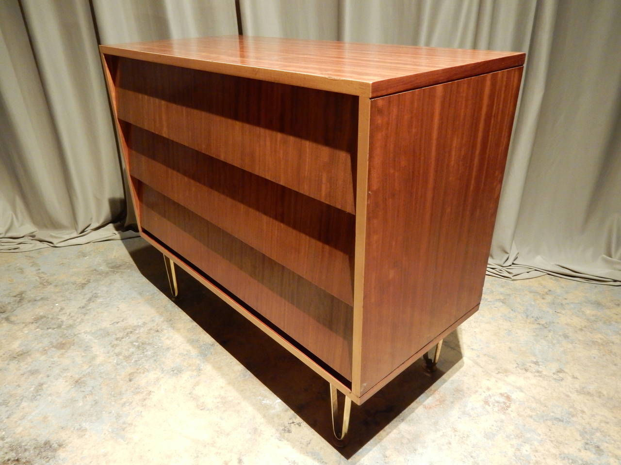 French Mid-Century Modern three-drawer louvered front commode on brass legs. Very nice warm color with contrasting band around front.