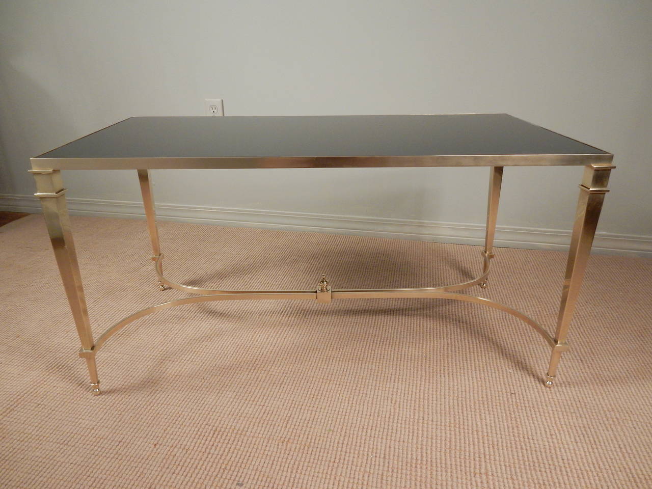 Beautifully crafted 1970s French brass neoclassical style coffee table with black glass top.