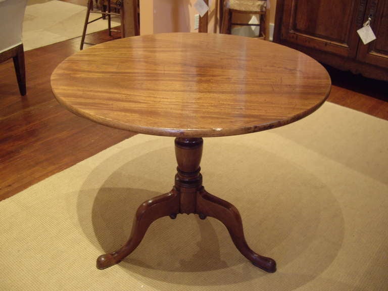 Beautiful carved faded mahogany tripod base English tilt top round table.