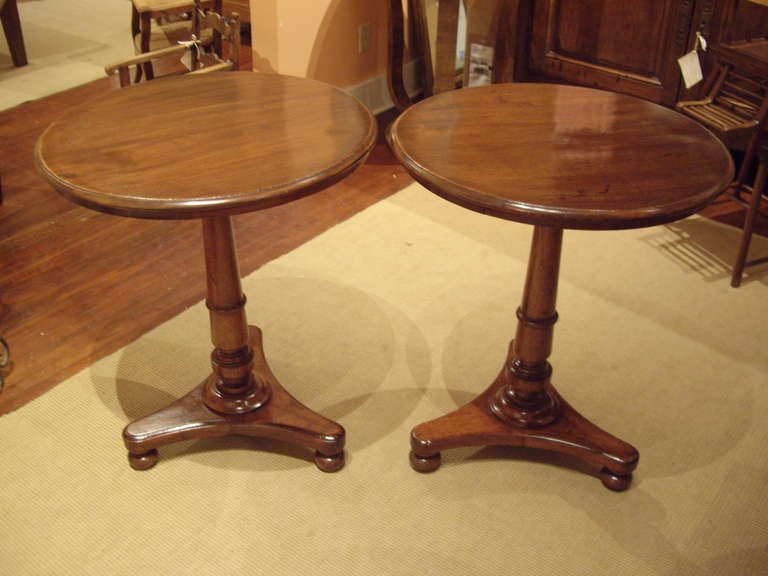 Pair of English faded mahogany 19th century round pedestal side tables.