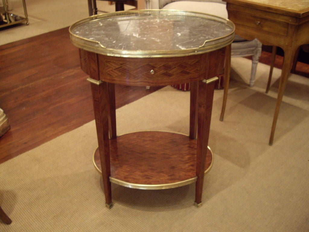 Beautifully inlaid walnut Louis XVI oval one draw table with marble top and bronze gallery