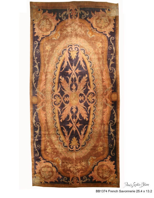 'An exceptional example from our collection of late 19th century French Savonnerie antique carpets, the cocoa field with floral sprays surrounding a garland wreath around a enlarged purple medallion, with an architecturally-inspired design of