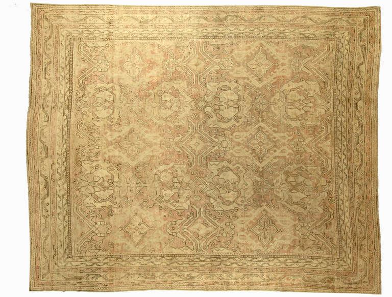 An early 20th century Turkish Oushak (Ushak) antique rug, the pale tan field with an stylized floral elements and wide border.