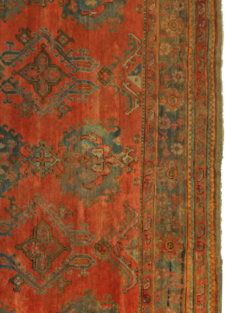 A Turkish Oushak with stunning red background and stylized decoration in various shades of green.