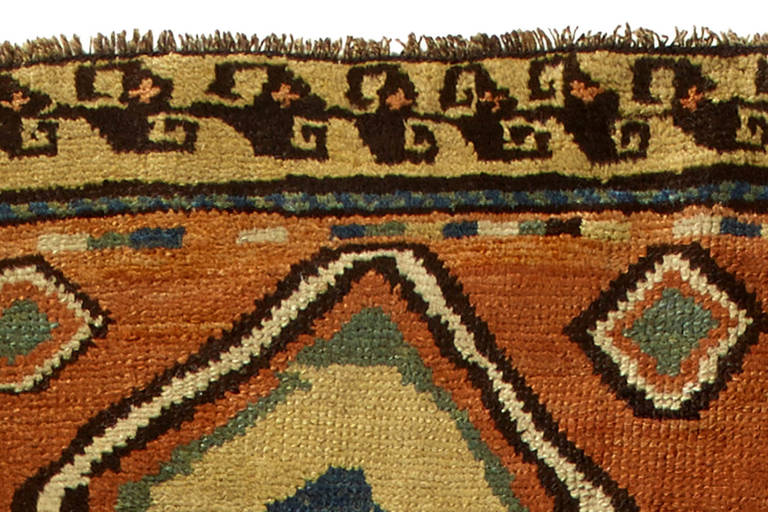 Antique Caucasian Karabagh runner in handwoven wool, with a central red field with diamond of various sizes and surrounded by irregular size yellow borders.