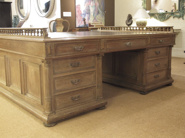A large scale partners desk with inset leather top with baluster galleried ends. The front pedestals with paneled doors enclosing document slides, the back pedestals with three drawers.
