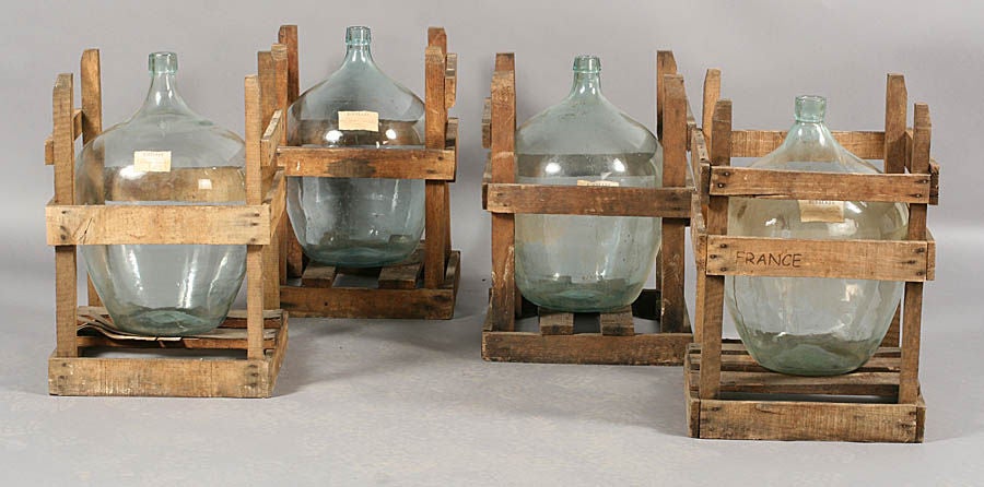 Set of 4 French wine bottles in crates.  Priced as a set of four.