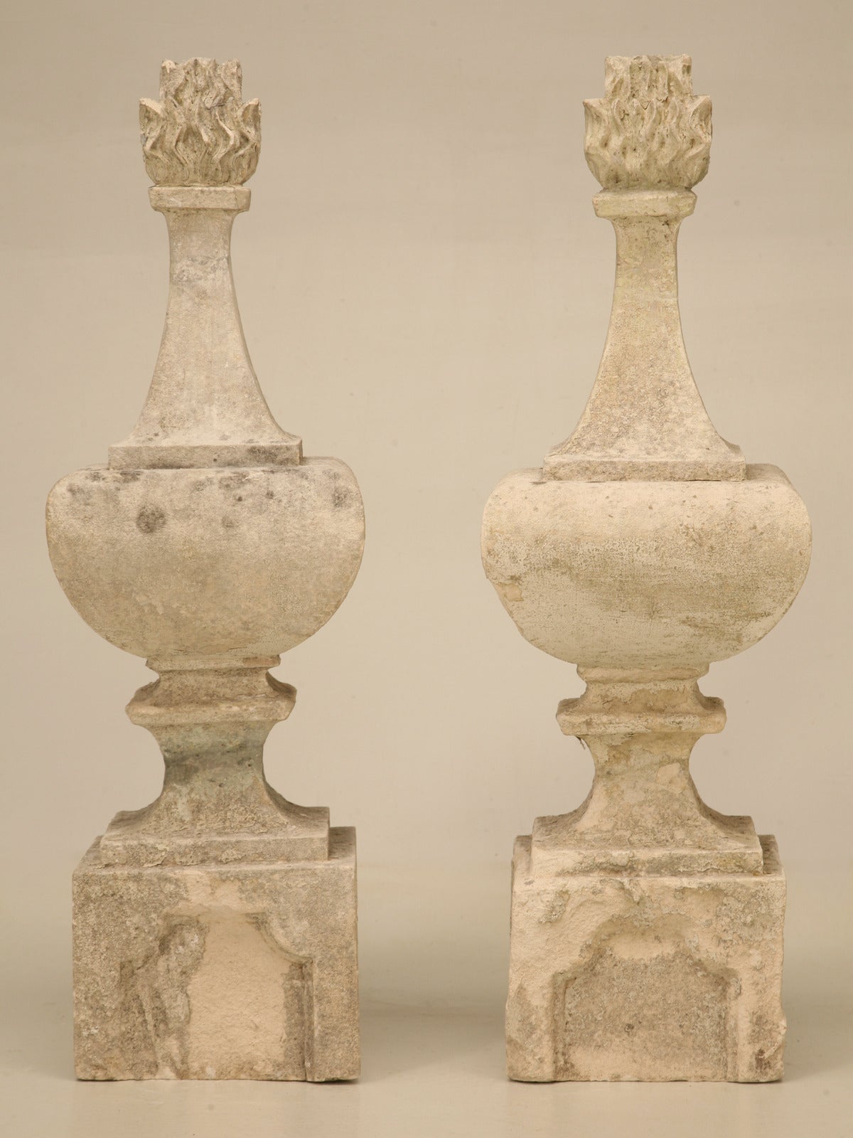 Pair of early 19th century hand-cut stone finials. Originally decorated a fence, rooftop or turrets, this exquisite pair of finials offer a unique flame detail on the tops. Please note previous repairs to the necks that have been professionally done.