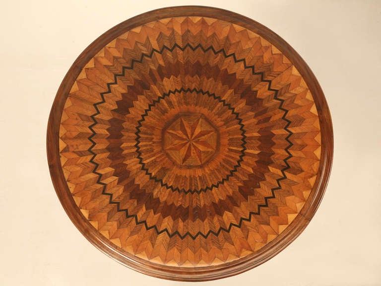 Circa 1880's real marquetry top table. It took over 1000 pieces of wood to create this kaleidoscope design. Ebony, cherry, fruit, walnut, satin and probably oak were used in combination to produce an almost a 3-D effect. No veneer, for these are all