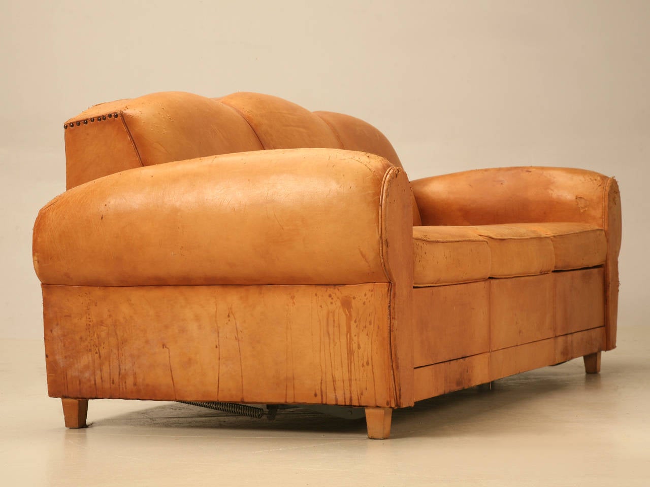 Vintage French Art Deco sofa that converts into a bed. All original leather and please note the cat scratches on the arms. The bed mechanism can be removed for softer seating should you desire.