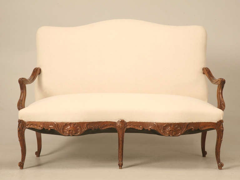Spectacular hand-carved figured walnut, Louis XV style settee. With it's graceful serpentine front, free flowing arms, and incredible carved aprons and legs, this settee is sure to please. Great carvings are measured in depth as to how good they