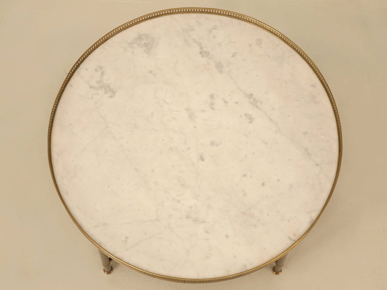 Vintage French round marble top coffee, or cocktail table with brass base. Done in a neoclassical style with a brass gallery edge banding. Marble is in very nice condition with no visible cracks or repairs.
The height provided includes the 3/4