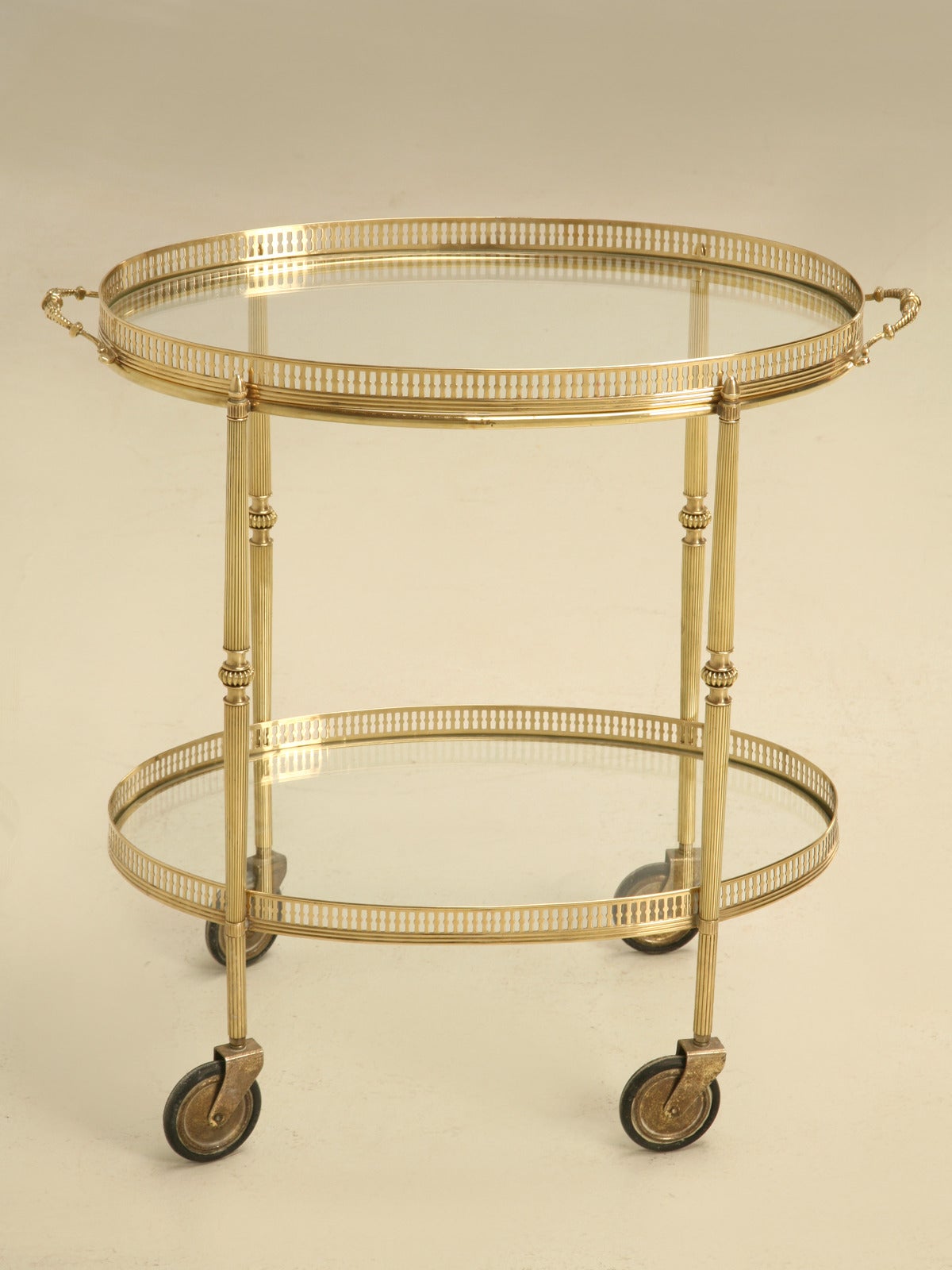 Beautiful vintage French oval shape brass tea, or bar cart with removable tray. We hand polished the brass and replaced both pieces of glass. We stock several brass carts on a regular basis, but the oval shape is hard to find, let alone in such nice