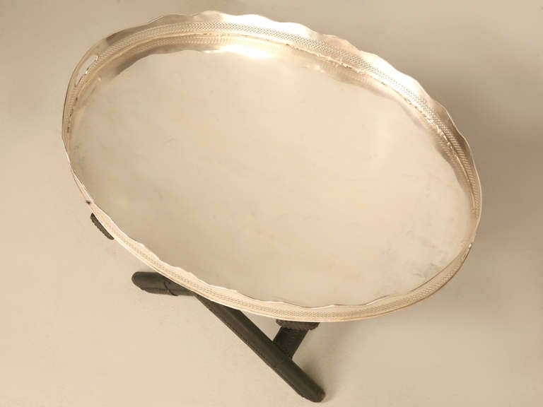 Circa 1940's French silver plate tray on stand. Graceful scallops with rope detail outline the circumference of the entire tray. Open fretwork adds another beautiful detail. The stand is upholstered in black leather with delicate, color matched nail