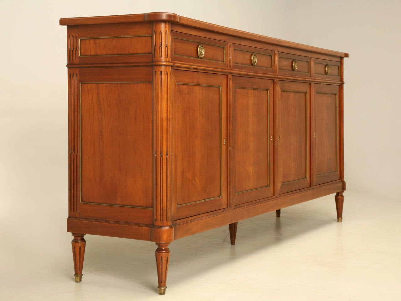 Vintage French Louis XVI style buffet with beautiful brass trim. Classic lines of a four-drawer over four-door model. The sideboard is completely original, both inside and out, and if you look very hard you can see some light surface scratches that