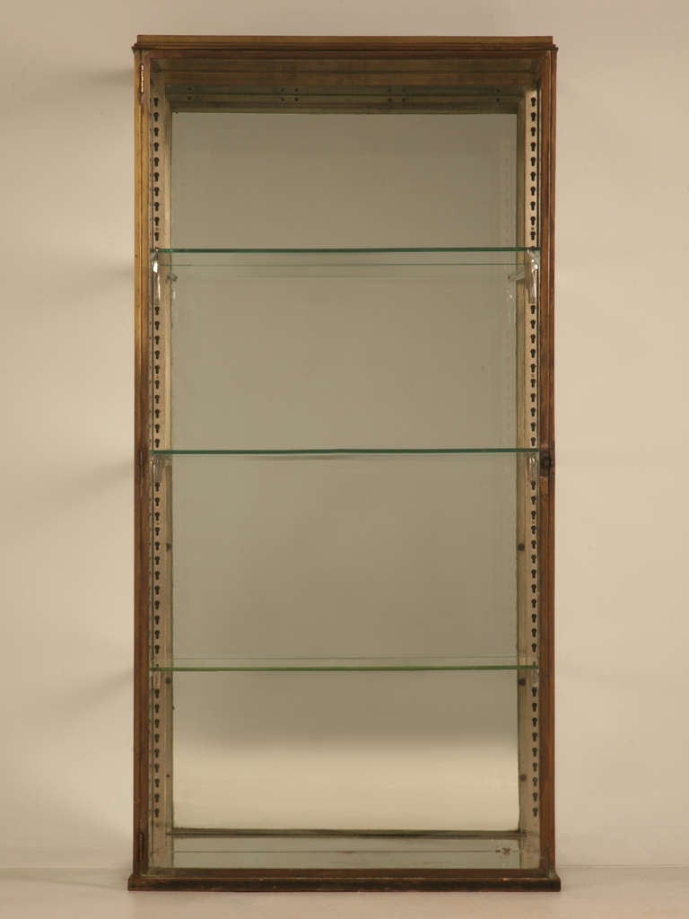 Circa 1920's beautifully constructed French display cabinet that might have been used in a high end department store. The frame is made from brass and retains its original patination. The inside back, top and bottom are mirror.
