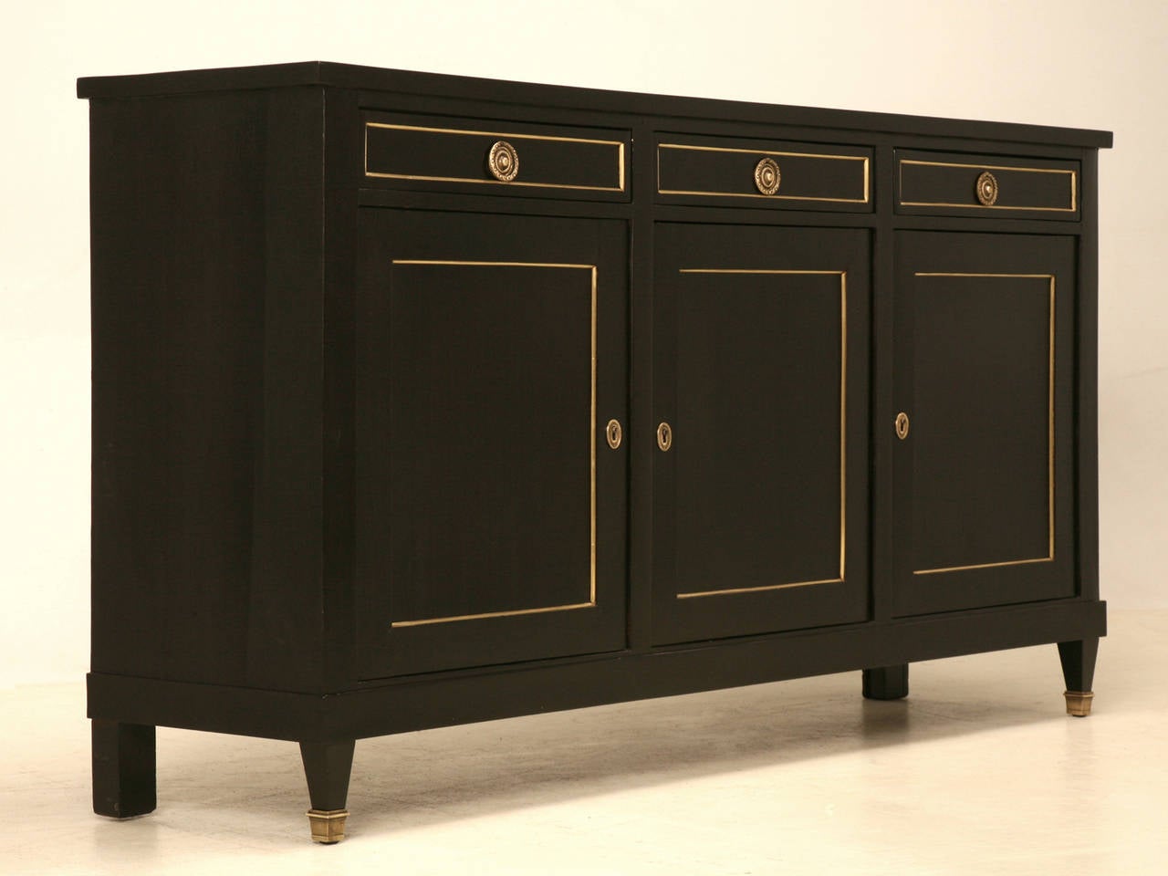 Classic French Louis XVI style buffet done in a proper ebonized finish where hints of brown peek through the black and all the grain of the mahogany remains visible. The black exterior is the antithesis of what you might typically see, because we