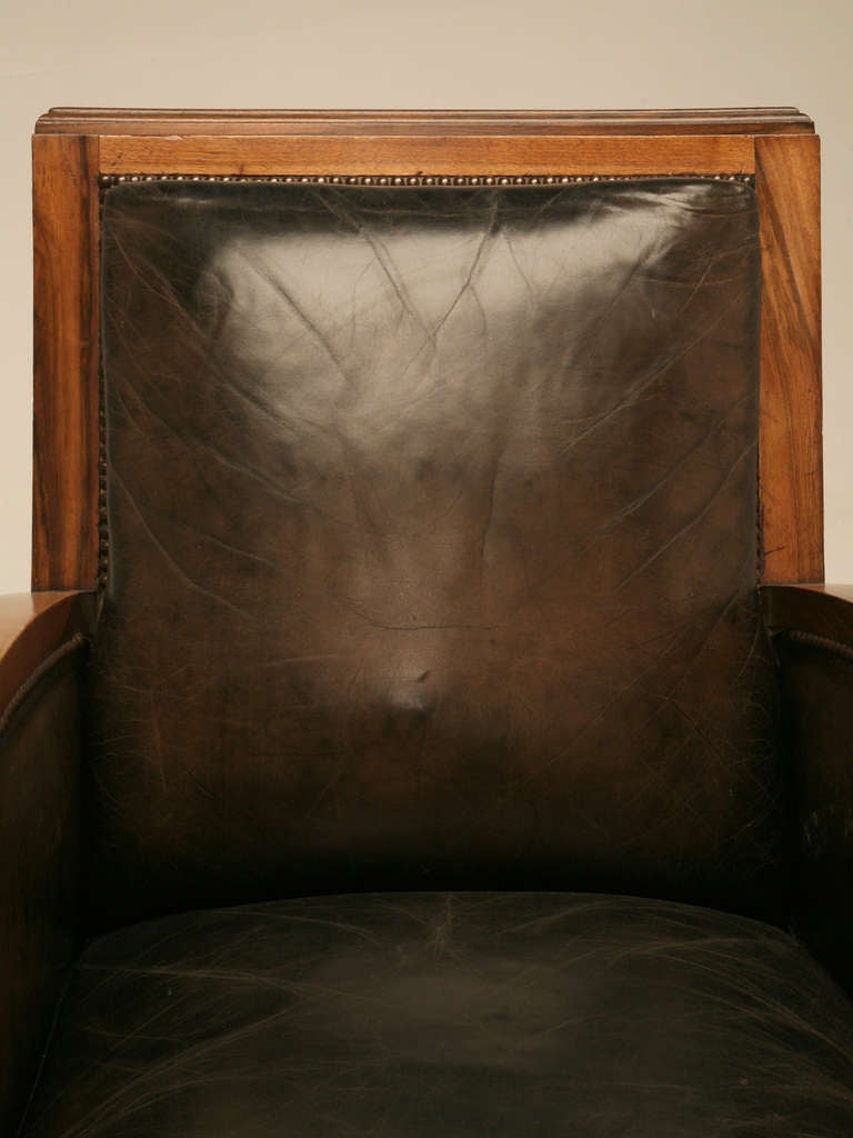 Beautiful circa 1930's original pair of French Art Deco leather and figured walnut club chairs. Absolutely incredible, this pair offer not only tons of style, but they are extremely sturdy and exceptionally comfortable. The richness of the dark