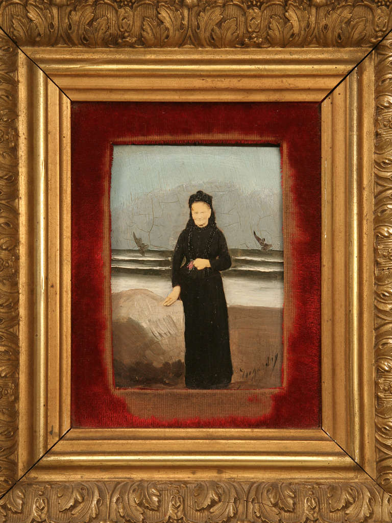 Circa 1900's French oil painting over a photograph. The face and hands of the woman are the only elements that show the photo. The dress and background are painted . It has a velvet inner frame that is very worn in areas. The outer frame is