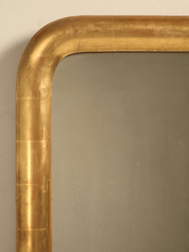 Louis Philippe water gilded mirror in an unusual large-scale, circa 1850. Received minimal restoration. This is original water gilding, not gold radiator paint.