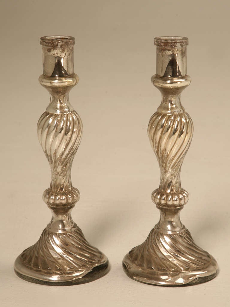 Pair of candlesticks are not new nor are they antiques, so I would simply called gently used. 
Mercury glass (or silvered glass) is glass that was blown double walled, then silvered between the layers with a liquid silvering solution, and sealed.