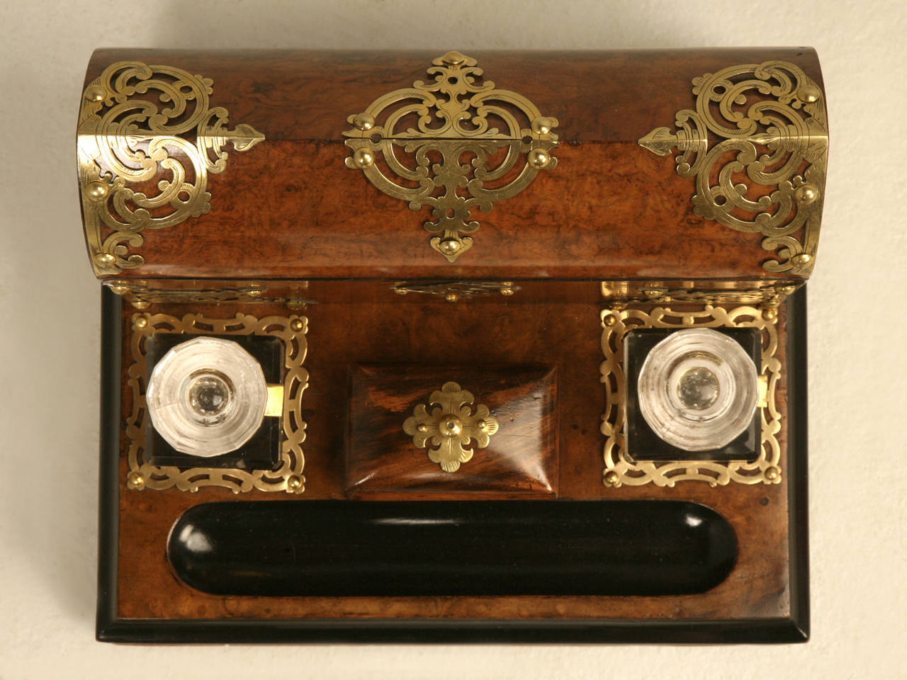 English brass-mounted burl walnut and rosewood travel desk, circa 1860s. Hinged lid has a domical beehive form with three section letter rack inside, mounted with pierced brass filigree on the corners and escutcheon; the base has two glass jar