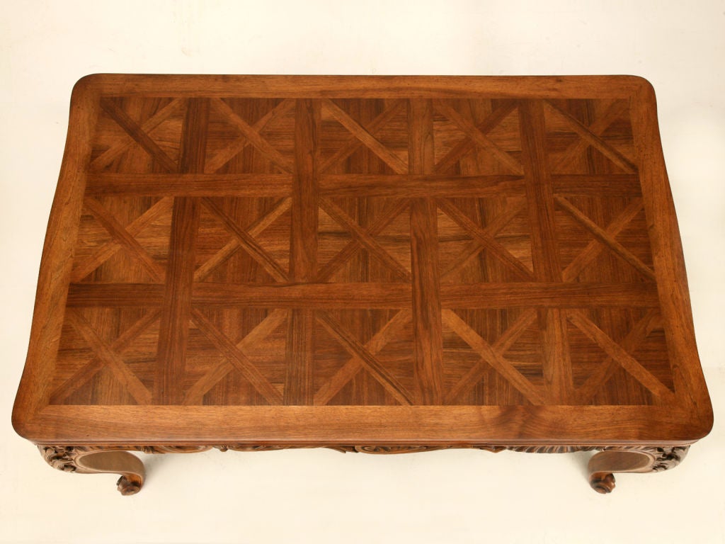 Exquisite heavily hand-carved French walnut draw-leaf dining tables like this one are few and far between. This one is stunning from its outstanding medium color showcasing the exotic grain of the walnut down to its sturdy heavily carved base that