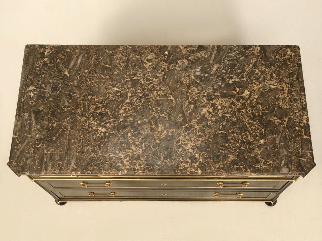 Breathtaking ebonized antique French 3 drawer commode with a striking, rich black finish, original polished brass hardware, and it's original marble top, too. This low chest of drawers would be awesome utilized most anywhere. Elegantly storing