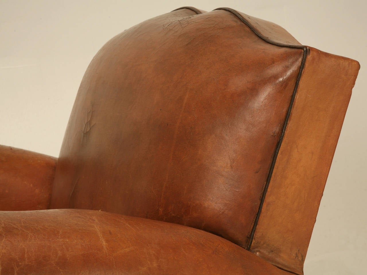 French leather club chairs, in a rich warm saddle tan color that only decades of use can provide. These were probably produced in the late 1930's and we did open the bottoms where we re-tied all the coil springs, re-glued the frames as necessary and