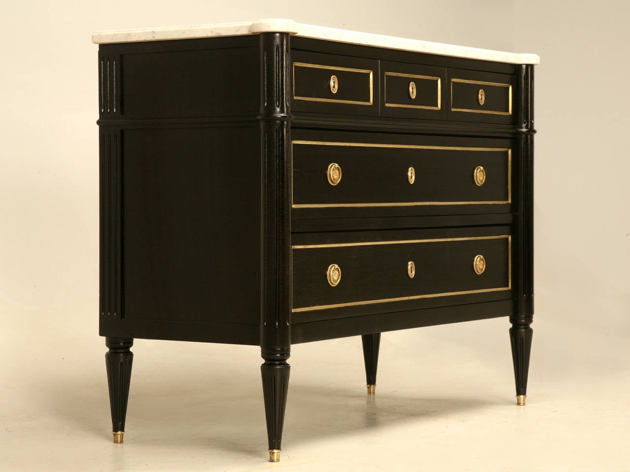 Classic Louis XVI style French commode done in a Jansen inspired rich ebonized black finish. Our Old Plank restoration department stripped the finish by hand, scrapping the entire chest, while using no chemicals. We then carefully applied several