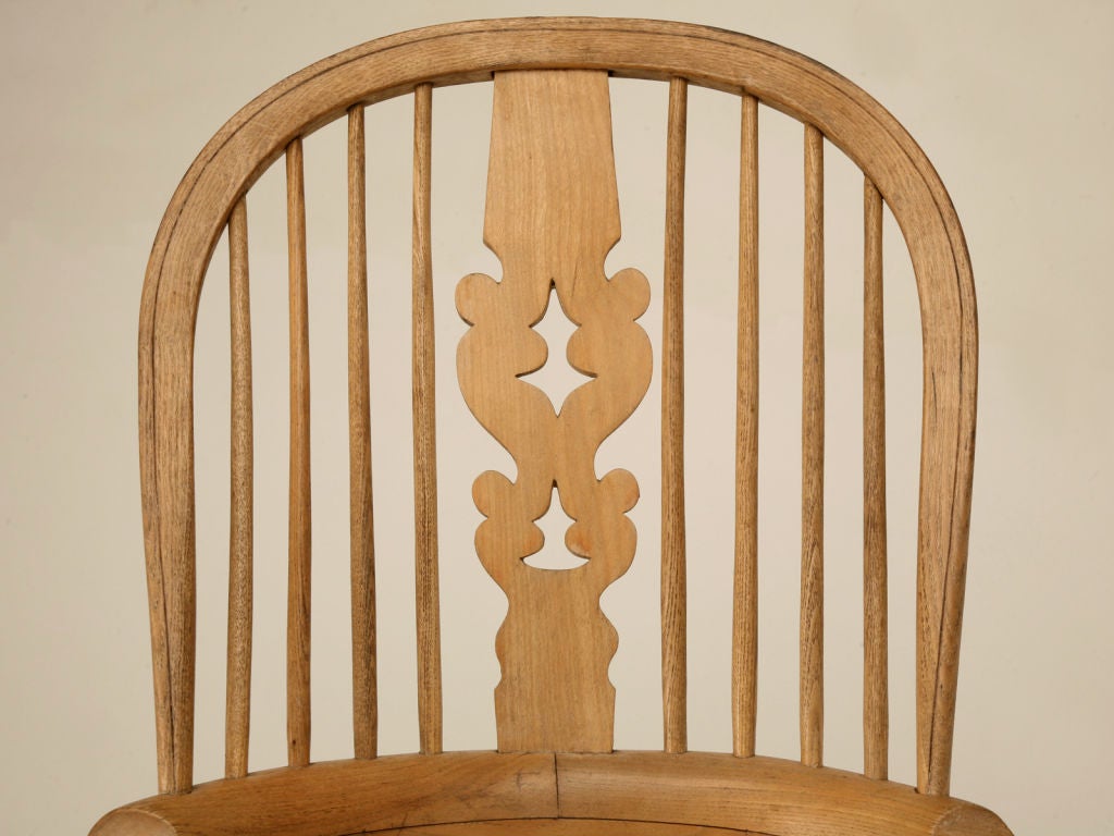 Magnificent pair of early 1800s English broad armed elm and oak his and her's Windsor chairs. In a much earlier time, it was quite the norm to have his and her's chairs, with the larger supposedly always his. This antique pair of Windsor arm chairs