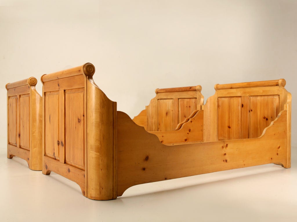 Exceptional pair of original vintage knotty pine twin sized sleigh beds. Perfect utilized most anywhere, this pair would be right at home mixed with antiques, in a child's bedroom, or even a more rustic environment such as a log cabin or summer get