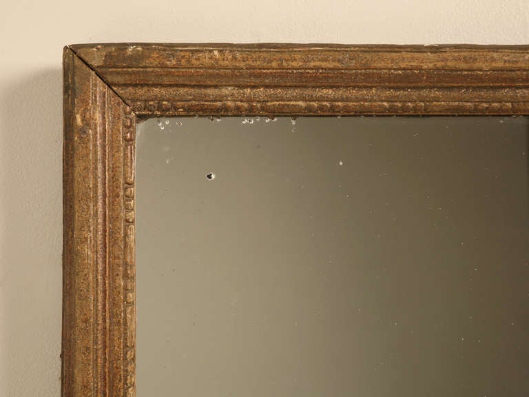 Circa 1840’s French gilded mirror in unrestored 100% all original condition. 
The patination on the frame is virtually impossible to duplicate, and reminds me of our c1700’s Italian dining chairs. There are evidences of silver coming through the