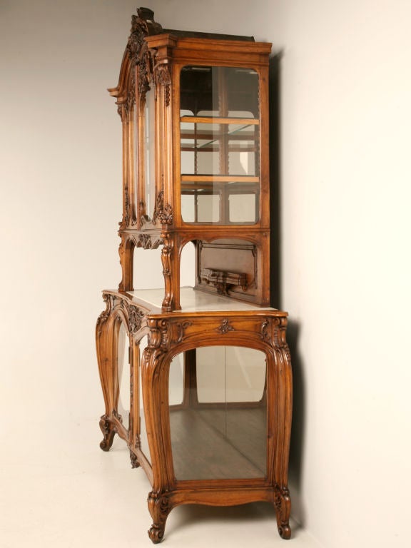 Dynamite original antique French Art Nouveau walnut and marble topped sideboard with both upper and lower glazed cabinets with doors. Perfect for a connoisseur of fine things, this fine cabinet not only offers a spot for serving food and drinks but,