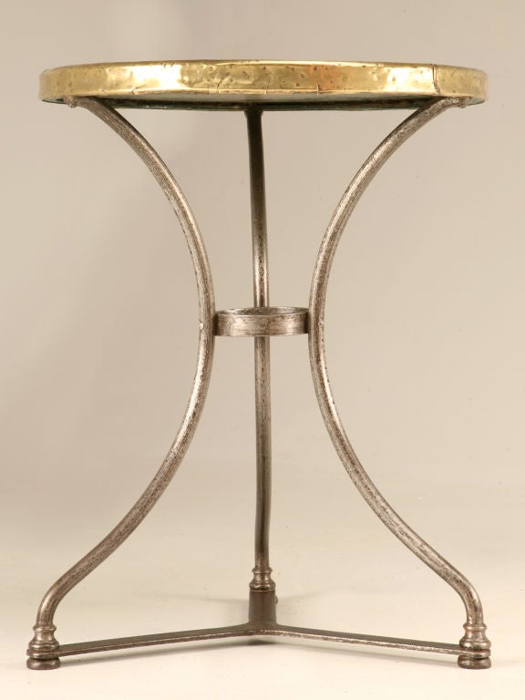 Breathtaking original antique French marble topped bistro table with three solid steel legs connected by a cross-stretcher and a steel loop for added stability. Topped with it's original brass aproned marble top, this table is ready for whatever you
