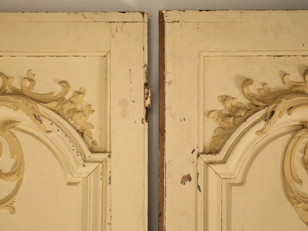 Original hand-carved 18th century French original paint panel doors just removed from a French chateau. A warm complimentary soft pale yellow finish highlights this outstanding pair of architecturally magnificent doors. The perfect thing to take