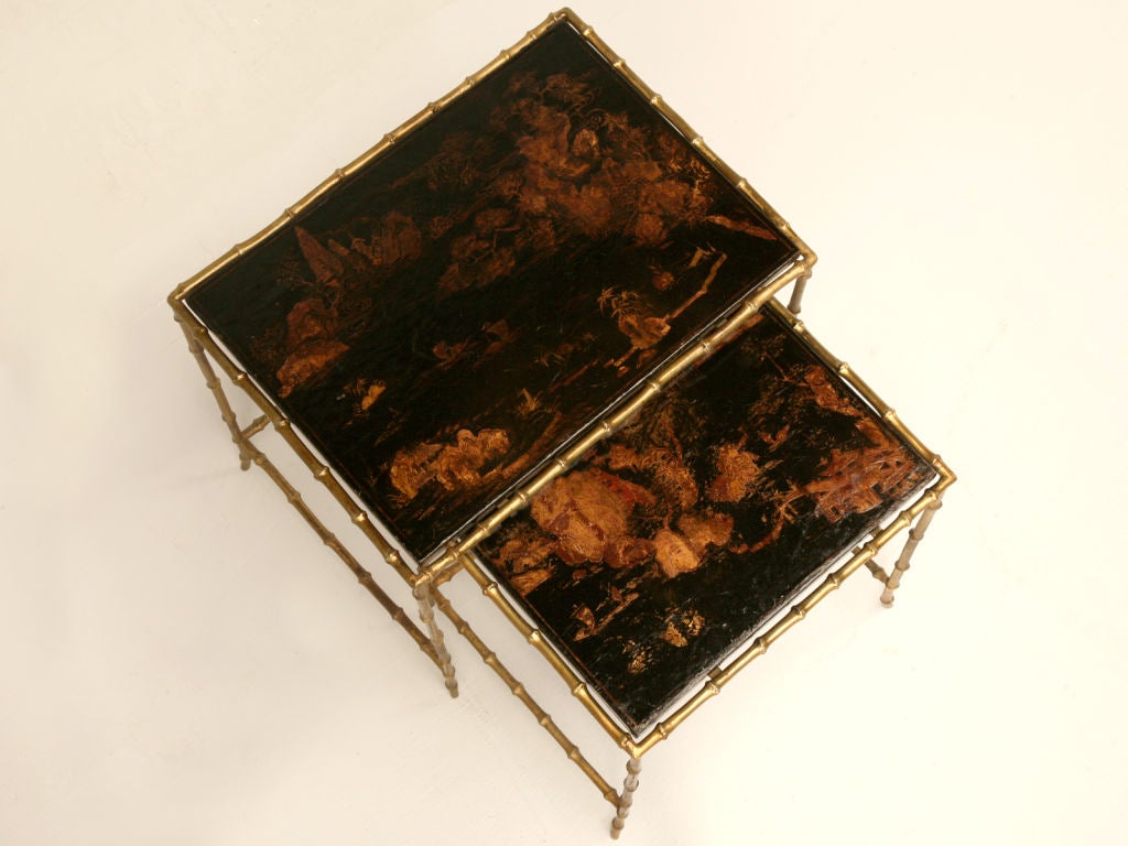 WOW! Our expert buyer has outdone herself once again, this time she located this enticing pair of vintage French Maison Bagues nesting tables. With details such as stylish bronze faux bamboo bases and original Chinoiserie tops, these fine tables