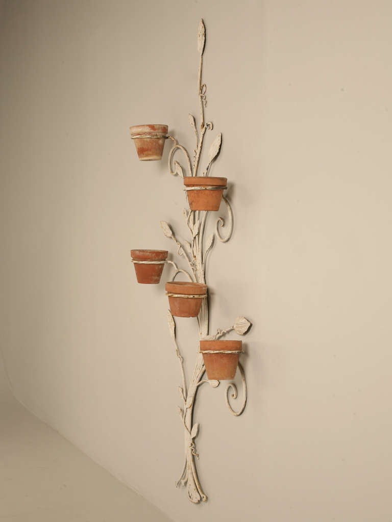 Circa 1950's American wall plant holder with a set of five clay pots. Structurally very sound, and can be used inside or out.