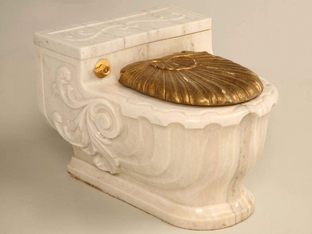 A magnificent work of art--this fine Sherle Wagner commode cover is still being sold today. Ingeniously designed to slide over a wall mounted commode, this scroll and flourish casing is the ultimate in luxury. Designed in a Aurora Marble Rose