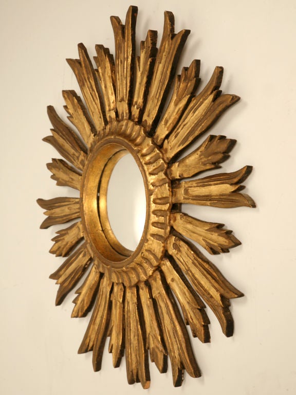 Stunning vintage Italian carved and gilded sunburst form convex mirror. Make a statement, our in-house designer usually showcases sunburst mirrors in groupings of five or more. They are also fine alone as an interesting accent. Whatever you choose,
