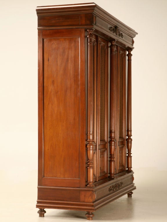 Spectacular antique French solid walnut four-door bibliotheque with nicely carved details. While remaining relatively low, this fine cabinet would be right at home in a kitchen full of cookbooks, a large stairwell landing utilized as a reading nook,
