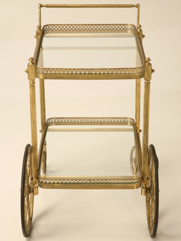 Outstanding vintage French brass and glass tea or bar cart. With its reeded bars, fleurettes and gallery edges, this cart is definitely appealing to the senses. Perfect for most any room of the home, these carts offer a ton of versatility. Use it in