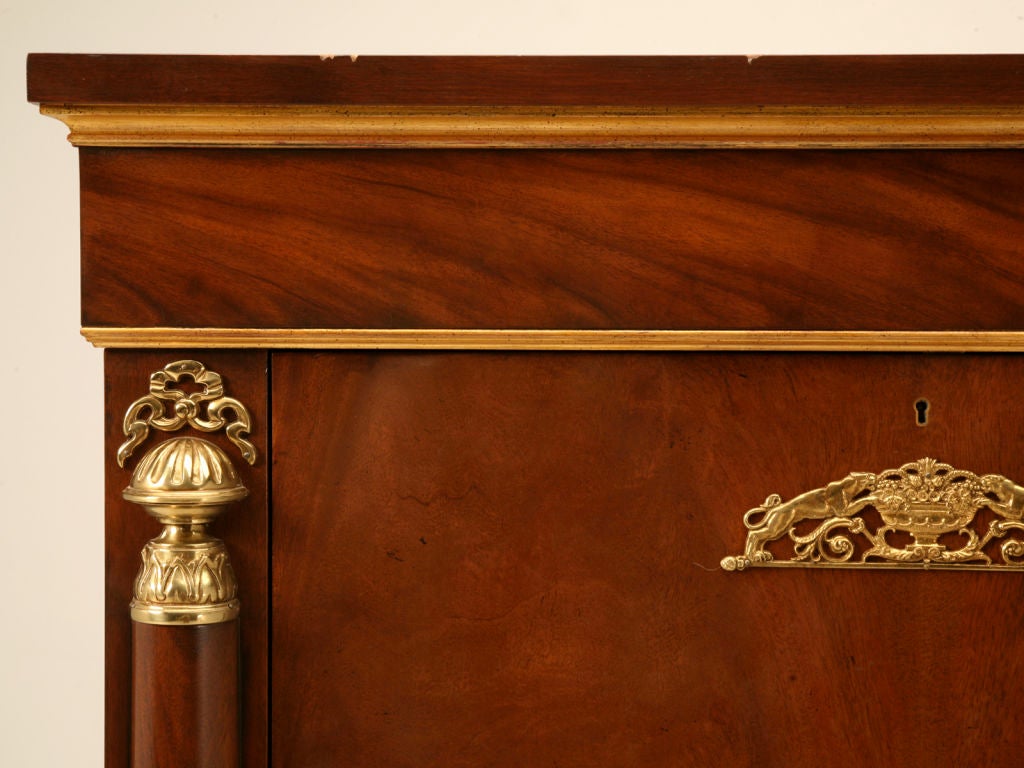 Absolutely stunning vintage crotch mahogany Empire style secretary or dry bar made by highly respected Baker Furniture Company. This wonderful secretary lends itself to being more formal with its distinctive crotch mahogany front highlighted with