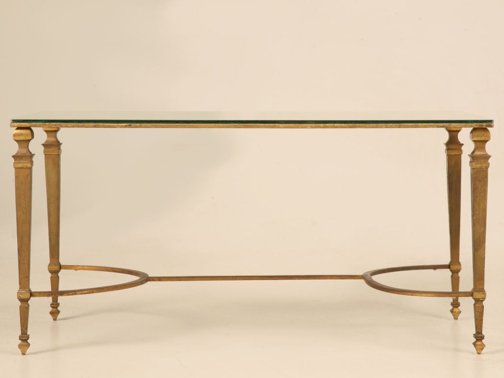 Extraordinary vintage French Maison Jansen neoclassical gilt bronze coffee table base married to a new mirrored glass top with an aged appearance. This enticing table pleases the senses with its dynamite design and with its quality craftsmanship