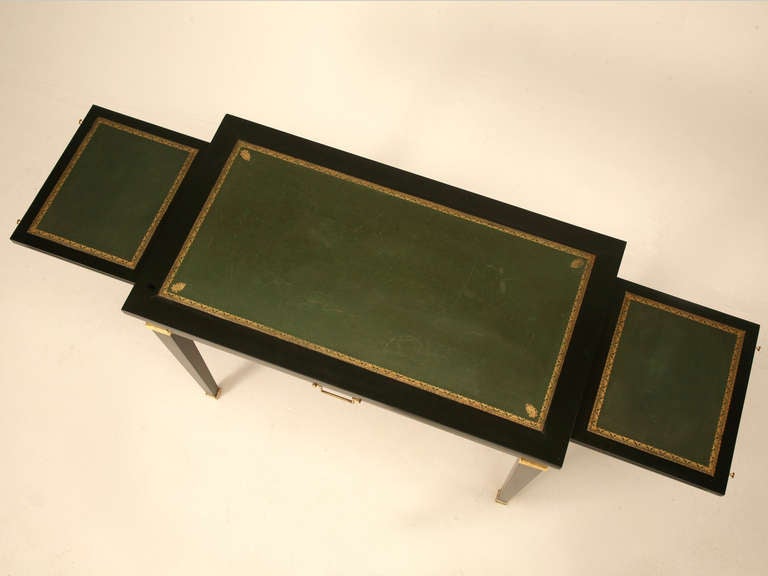 Circa 1950s ebonized French Directoire style desk with its original leather writing surface. What makes this so unusual is the petite size, and I cannot ever remember seeing a French desk this small with a leather top.