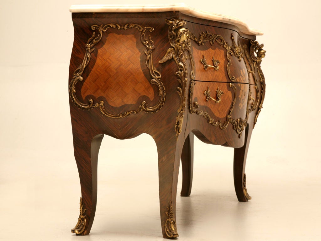 Outrageous vintage Italian style 2 drawer bombe commode with marquetry, ormolu accents, and an amazing marble top to boot. If you appreciate fine quality, you're going to love this phenomenal chest. Perfect so many places, this commode would be