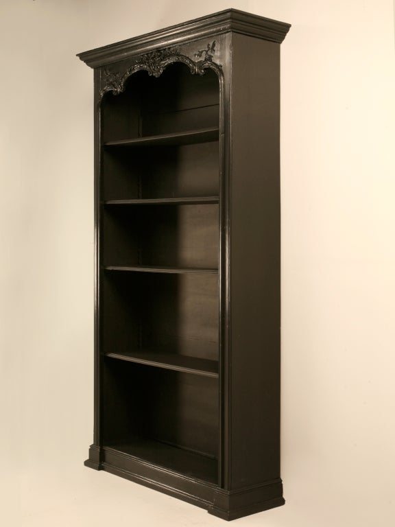 Ebonized antique French Louis XV open bibliotheque found in the South of France with adjustable shelves and old world wooden-peg construction. With its sweeping cornice and decorative touches, this antique bibliotheque is most definitely the cat's
