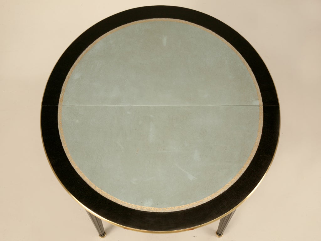 Stunning vintage French Louis XVI style table constructed of  gorgeous ebonized mahogany, polished brasses, and a spectacular pale French blue tooled leather top. Perfect as a games table in the formal living room, as a gueridon displaying a large