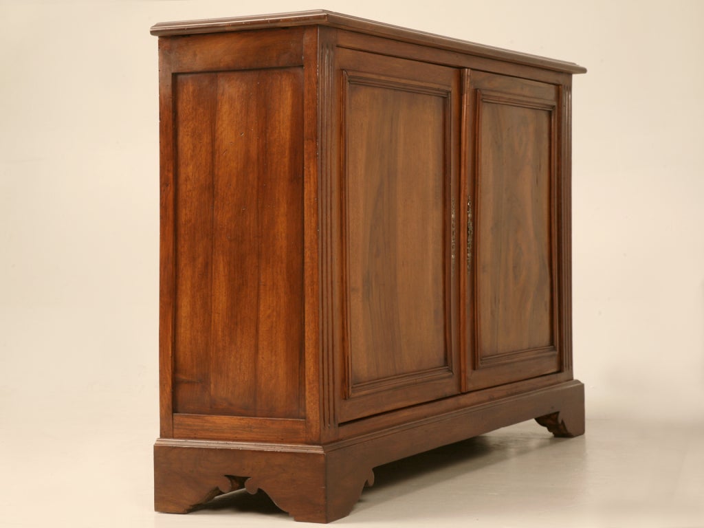 Breathtaking antique French solid walnut buffet. Showcasing burled walnut on the two doors, this shallow buffet offers plenty of options for utilization. Whether its used in the dining room as an exquisite buffet storing extra linens, in the foyer