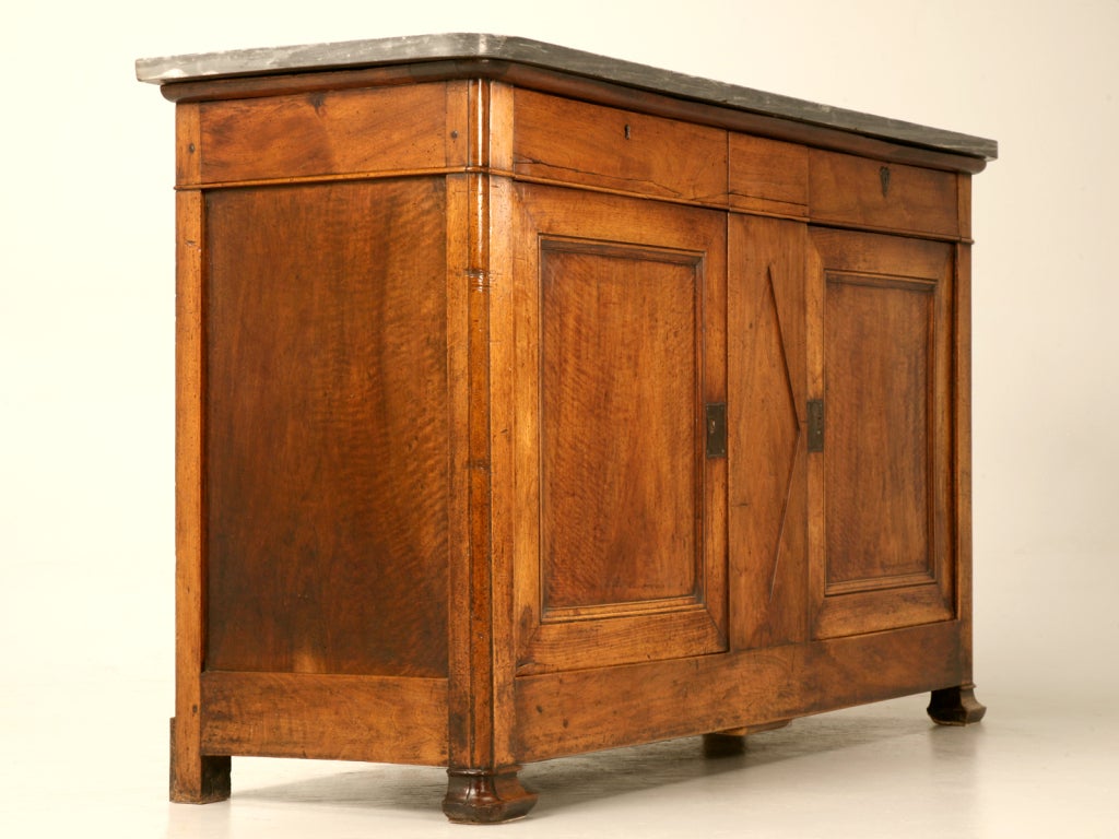 Every once in a great moon, we are fortunate enough to come across a truly exceptional piece of furniture, and this all original 200 +/- year old French Directoire figured walnut buffet is no exception. Complimented with its uniquely colored marble